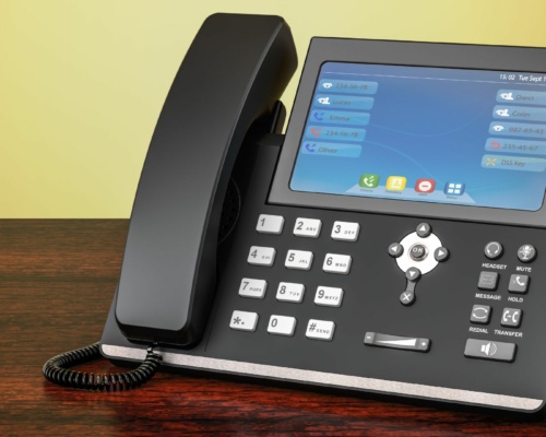 modern voip phone The office desk telephone, epitomising brand consistency, features a touchscreen, buttons, a coiled cord, and a handset on a wooden surface. Its screen displays an options menu and the date set to Tue 17 Sep, maintaining uniformity across all devices.